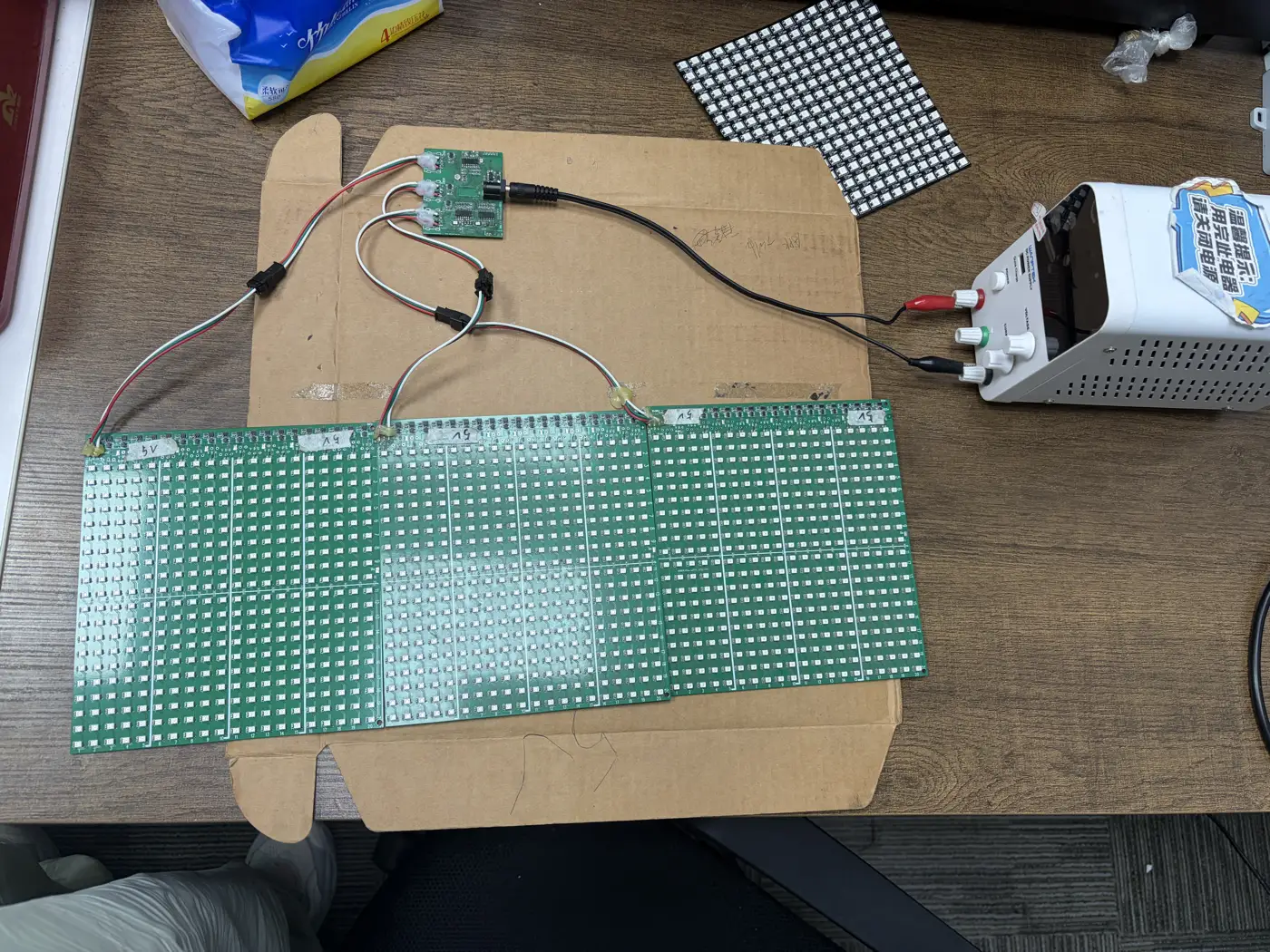 Pixel LED panels, controller boards and a bench power supply connected on our workbench.